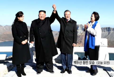 金正恩与文在寅在天池前牵手合影。（韩国YTN电视台截图）