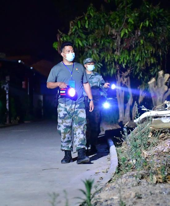  瑞丽边境疫情防控执勤点，工作人员在夜晚坚守检查登记工作岗位（图源：新华社 陈欣波 摄）