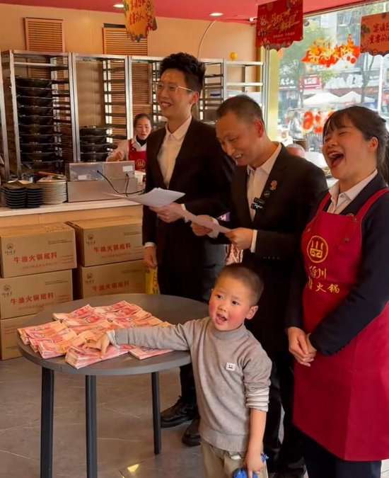  黄厚明（中）给员工发现金