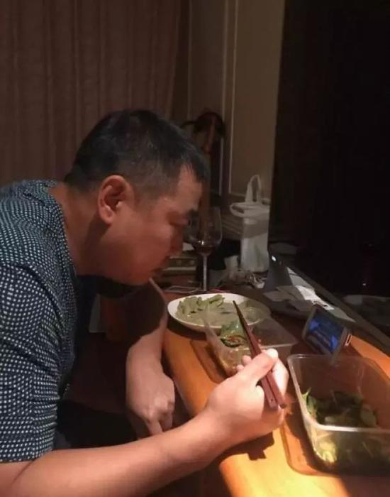 刘国梁用手机看全运会上弟子们的比赛。