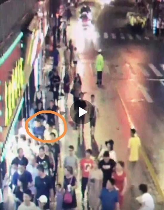  张易和欧阳一起走在南京东路人行道上。图片来自网络视频截图