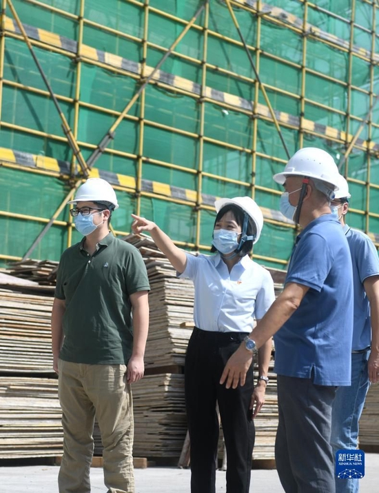 陆秀兴（左二）在佛山市禅城区张槎街道古灶村内一处产业园工地上与投资方交流（2022年9月7日摄）。新华社记者 卢汉欣 摄