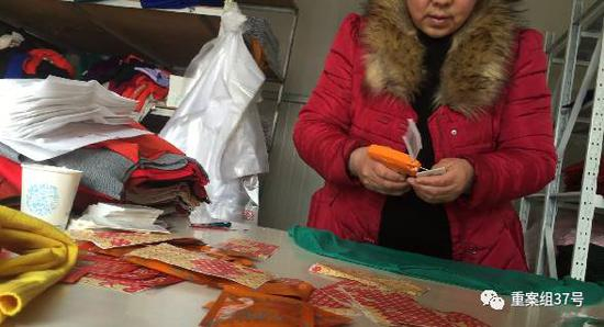 　　▲3月2日，清河县东高庄村，一家专门给淘宝店铺供货的商铺。一名妇女正给一件针织衫贴上标注有“羊绒”含量“85%”、“一等品”、“羊绒精品”字样的标签。