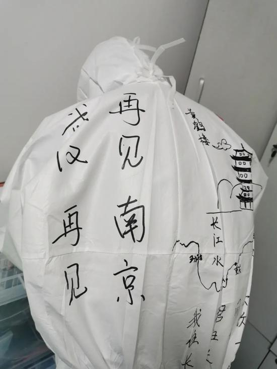 4月10日，江苏援鄂医疗队队员在防护服上写字留念。新京报记者 王双兴 摄