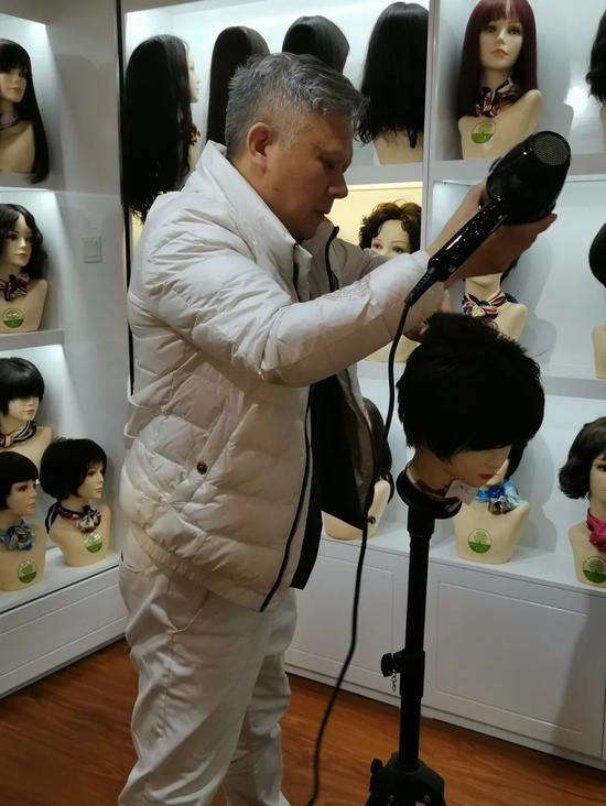 2021年3月18日，王峰在为假发做发型。图片均由本报记者尹平平摄