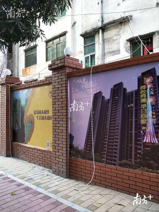 冼村围闭外墙上，电线从墙内延伸到墙外地面。