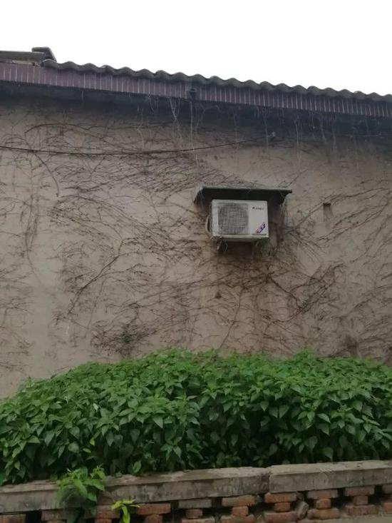 （杨和同家墙壁上悬挂的的空调外机）