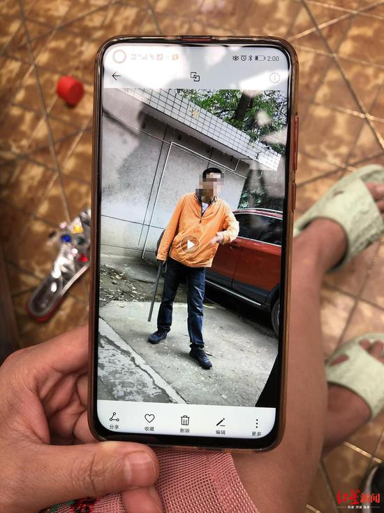 ↑小区居民许女士手机拍摄的当时拿着铁棍追打流浪狗的刘飞。