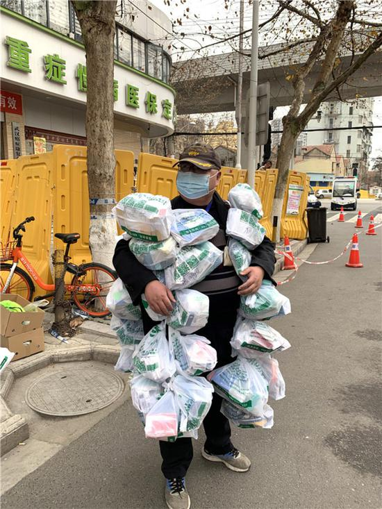 在武汉市江岸区黄石路汉口大药房，惠民苑社区网格员丰枫把为居民购买的药挂在身上（2月24日摄）。新华社发