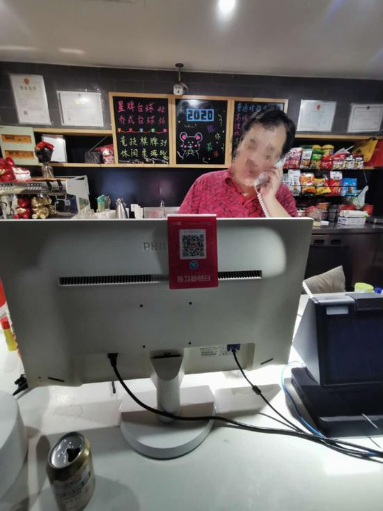  台球厅商家正在接听预订场地的相关来电。