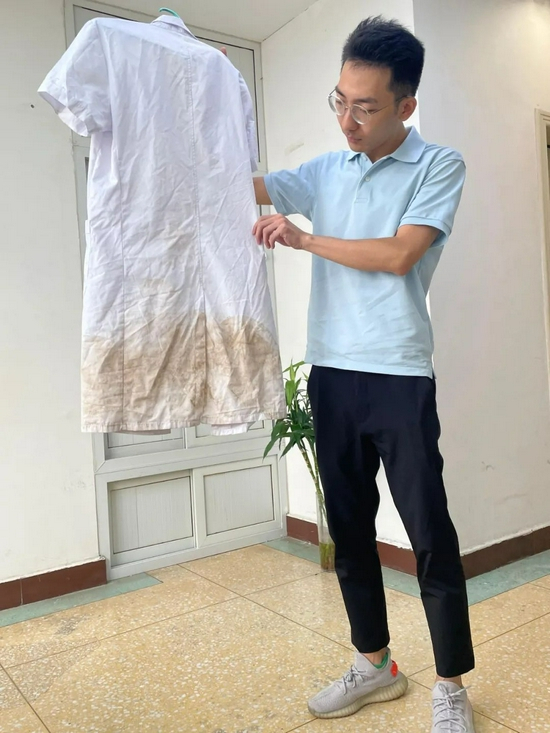  于逸飞向记者展示当时穿的白大褂。记者任卓如摄