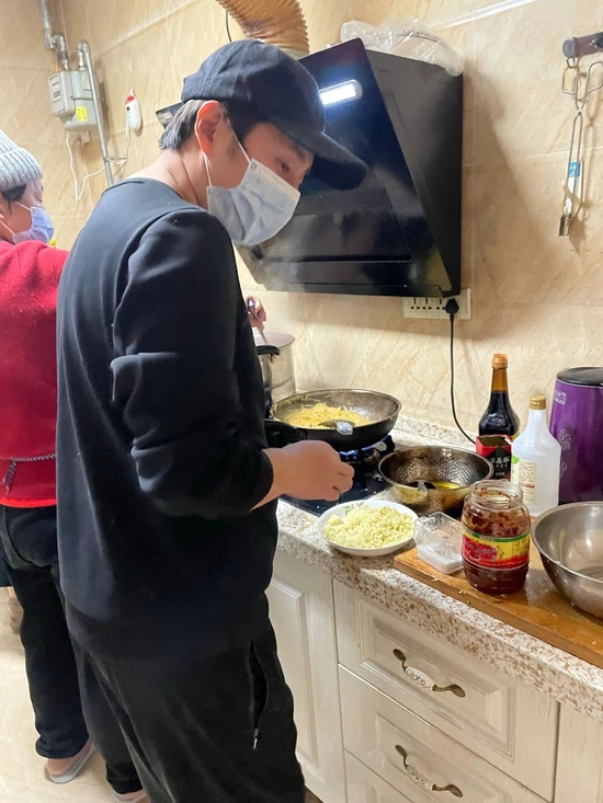  ▲明庭贵和母亲正在家里做饭。受访者供图