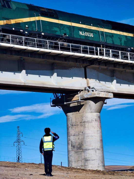  次仁欧珠在向驶过的列车工作。徐驭尧摄