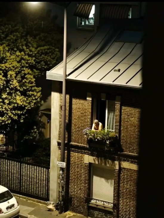  △当地居民打赤膊在窗边消暑。