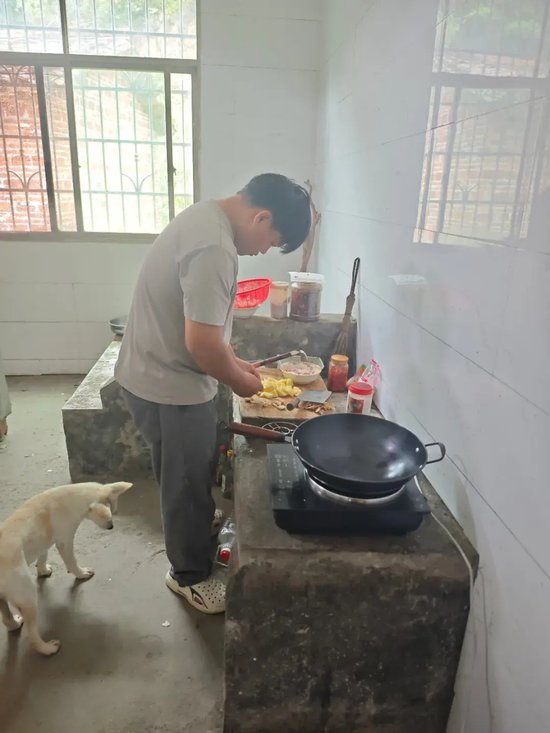 　钟彬正在给家人做饭。图/九派新闻 黄家樑