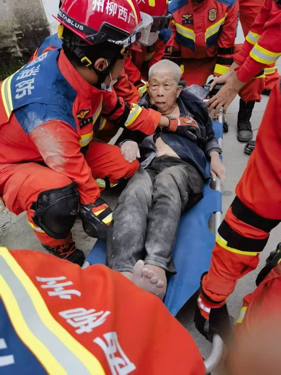  5月18日，救援人员在太阳村镇上等村受灾现场搜救出91岁老人。（柳州消防供图）