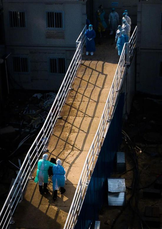 2月4日，医护人员将患者送入武汉火神山医院病房（无人机照片）。新华社记者 肖艺九 摄