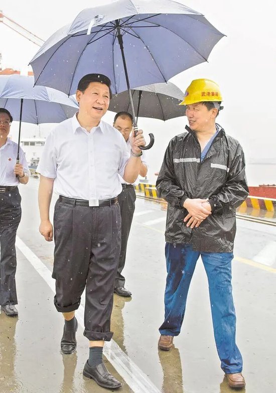  2013年7月21日上午，习近平冒雨来到武汉新港阳逻集装箱港区考察。（新华社发）