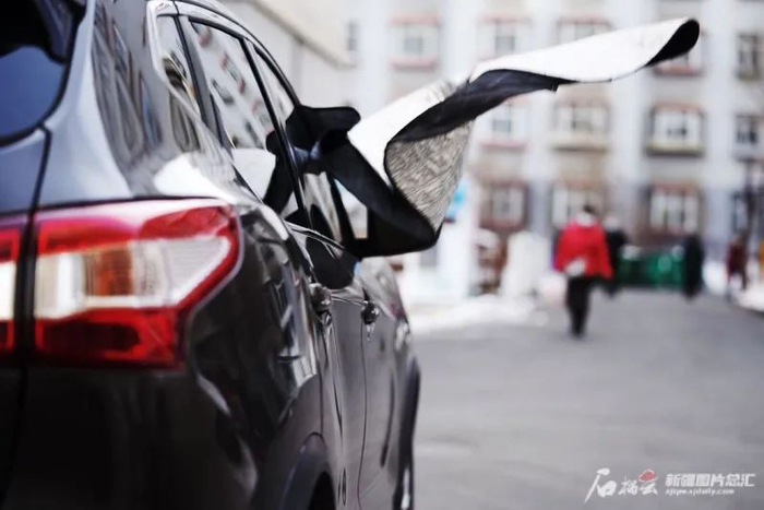 乌鲁木齐市西山路一小区内，一辆车的车衣被吹得随风狂舞。石榴云/新疆日报记者张万德摄