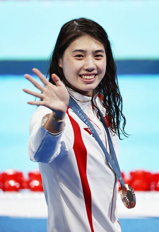 8月1日，季军中国选手张雨霏在颁奖仪式后向观众招手。当日，巴黎奥运会游泳项目女子200米蝶泳决赛在拉德芳斯体育馆举行。新华社记者 雒圆 摄