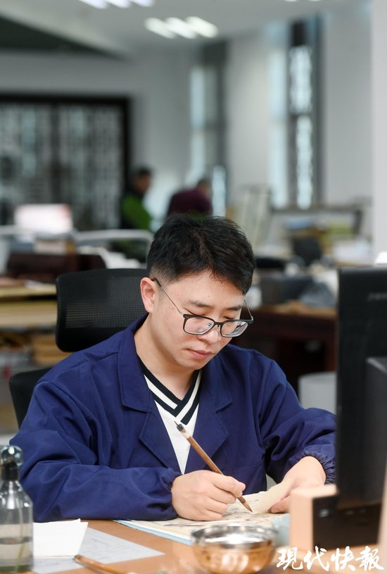 丁峰正在伏案工作