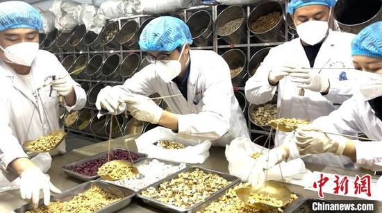 图为药剂师正在称重抓药。　陈峰　摄