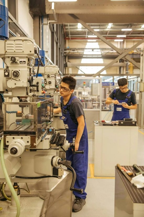 在亿迈齿轮的培训中心，学徒练习操作机器（蔡小川 摄）