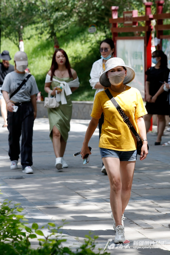 6月12日，乌鲁木齐市水磨沟公园，市民在林荫下散步休闲。石榴云/新疆日报记者 秦鹏摄