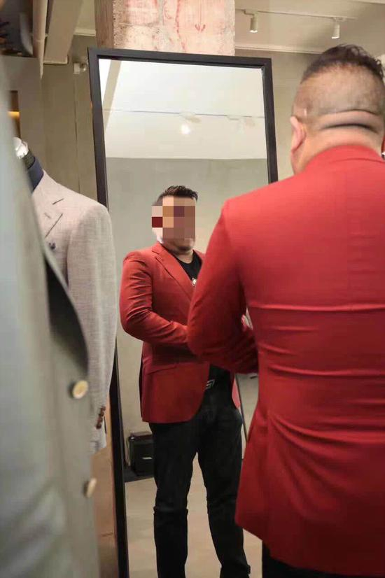 孙小果在昆明一家定制西装店试装，拍摄时间2018年。&nbsp; 受访者供图。