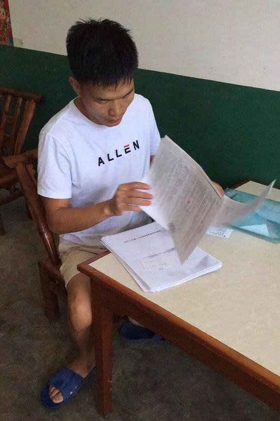 饶小虎翻看签订的船员派遣协议。新京报记者肖薇薇 摄