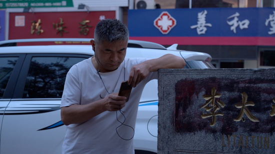  ▲9月11日早上6时许，郭刚堂出门晨练，在路途中回复寻亲求助信息。新京报记者 戚厚磊 摄