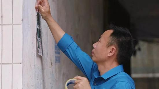 被拐儿童父亲申军良在贴寻人启事。受访者供图