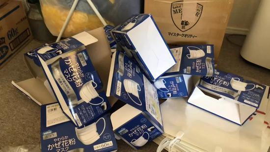 他们将盒装口罩拆封，方便邮寄。