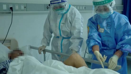 4月11日，转入湖北省人民医院后，毛二莉叮嘱对方医院的护士为老安做康复练习。新京报记者&nbsp;解蕾摄