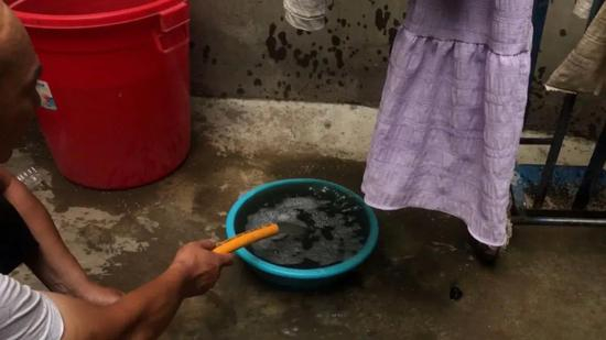 6月11日傍晚，八四集后街一位商户家后院水井抽上来的井水呈黑色，并有一股不太浓烈的臭味。新京报记者 肖隆平 摄