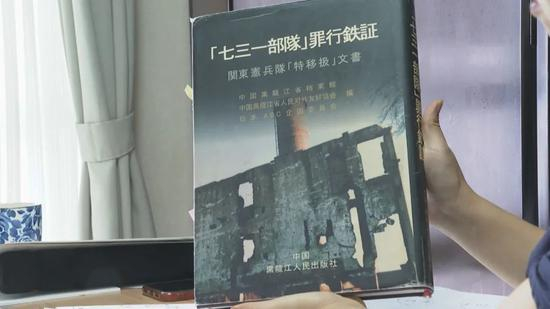 山边悠喜子给记者展示她参与整理的书籍——《“七三一部队”罪行铁证》。（视频截图）