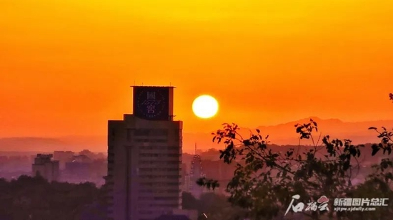 6月13日早晨，乌鲁木齐市天气晴朗，火红的朝阳从天边升起。石榴云/新疆日报记者张万德摄