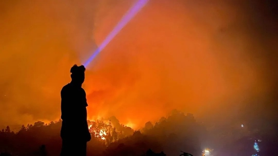 　志愿者在山顶观察火情。