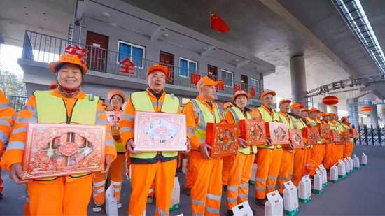 ▲环卫工开心地领取礼包