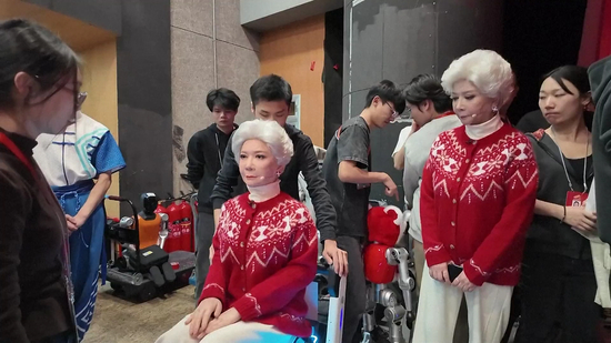 ▲在2026年总台春晚的现场，蔡明与机器人同台表演小品，站在她身边的，是松延动力研发的人形机器人：一个与她容貌神态几乎一致的仿生人形机器人 图据视觉中国