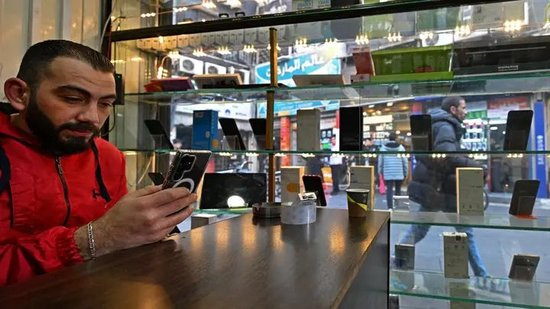 2025年1月12日，一名顾客在大马士革塔市场一家商店体验手机。 路透社