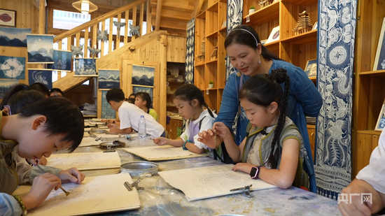  陆勇妹正在教孩子们学习蜡染技艺（央广网发 吴光辉 摄）