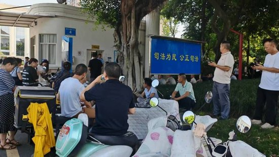  2026年7月24日上午，四川省仁寿县高家镇罗汉村部分村民守在眉山市人民法院门口等待开庭。（高艺峡|摄）