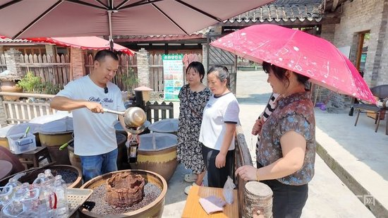  酱园坊内，刘畅正在为游客们灌装酱油（央广网记者 昌思荣 摄）