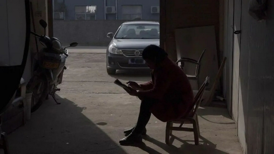 12月12日，韩仕梅坐在自家门口发诗到短视频平台。新京报记者 戚厚磊 摄