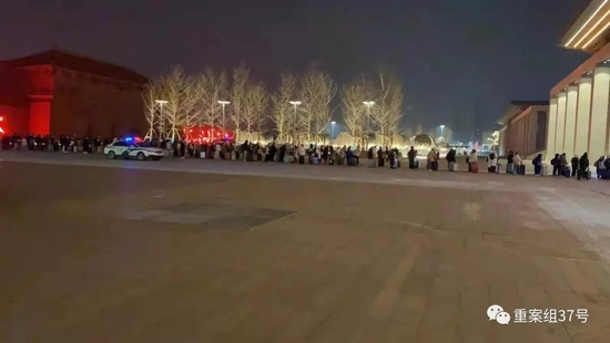  2021年12月27日晚10时许，西安火车站站前广场，滞留考生排起队伍登记信息。受访者供图