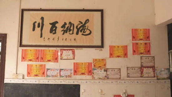  张石金家里的一面墙，贴满了4名孩子的奖状（图源：南风窗记者黄茗婷 摄）