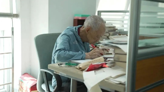  ·沈燮元在工位上校订书稿。