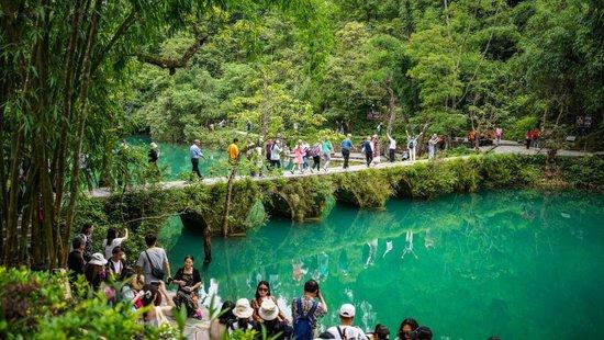   In early summer, the Xiaoqikong Scenic Spot in Libo County, Qiannan Buyei and Miao Autonomous Prefecture, Guizhou Province, is green and beautiful, attracting many tourists. Photographed by Tao Liang, a reporter from Xinhua News Agency