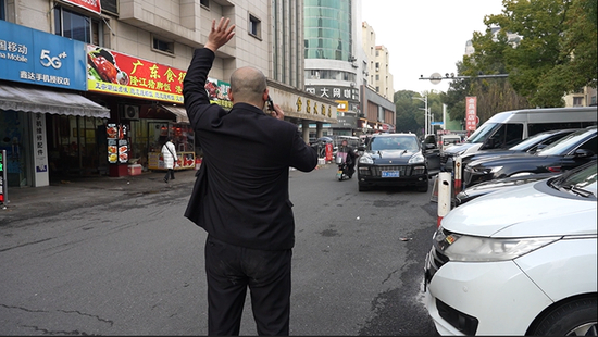  张熹下车接乘客。图/九派新闻邵骁歆